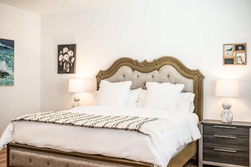 a bedroom with a large bed and two lamps at Spacious 5BR Getaway w Game Room & Modern Comfort in Fontana