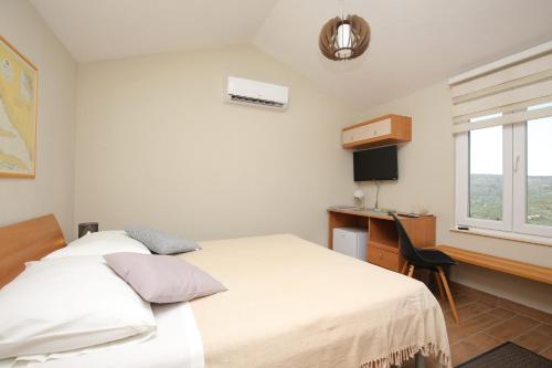 a bedroom with a bed and a desk with a computer at Apartments with parking space Stupin Celine, Rogoznica - 23929 in Rogoznica