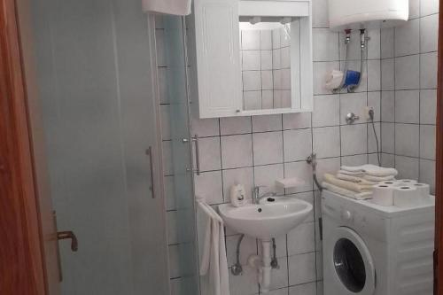 a bathroom with a sink and a washing machine at Apartments by the sea Drace, Peljesac - 24429 in Drače