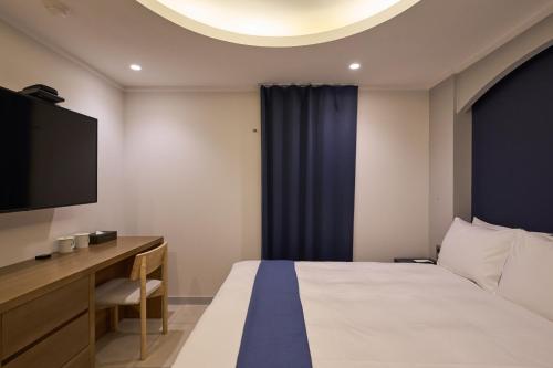 a hotel room with a bed and a flat screen tv at Blueduck hotel in Seoul