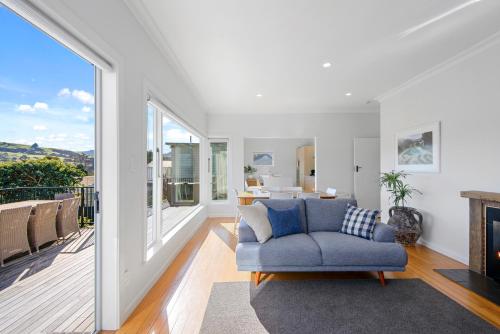 un soggiorno con un divano blu e un camino di Spacious Sunny Family Home in Akaroa ad Akaroa