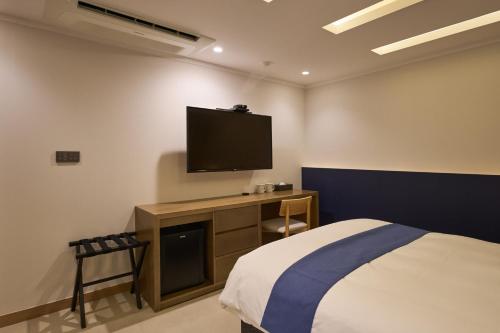 a bedroom with a bed and a flat screen tv at Blueduck hotel in Seoul