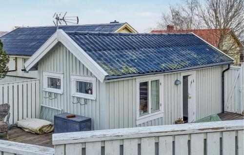 a house with a solar roof with a white fence at Lovely Home In Hönö With Harbor View in Hönö