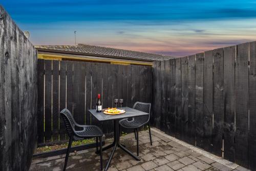 a table and chairs on a patio with a fence at Aroha Motel & Apartments in Auckland
