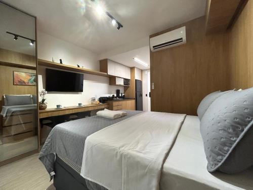 a bedroom with a bed and a desk with a computer at Studio 1805 - A Poucos Metros do Allianz Park in Sao Paulo