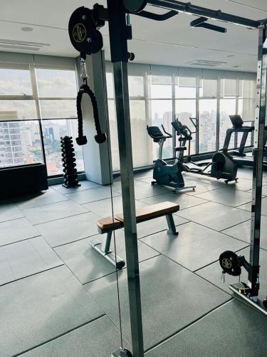 a gym with tread machines and a bench in a room at Studio 1805 - A Poucos Metros do Allianz Park in Sao Paulo