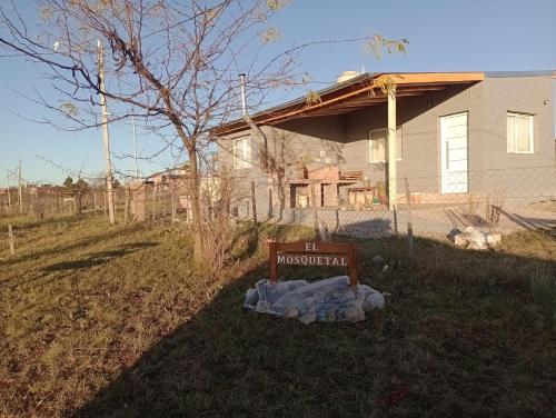 a house with a sign in front of a yard at Elmosquetal in Villa Yacanto