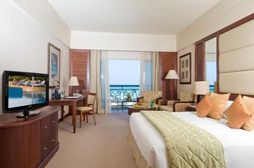 a hotel room with a bed and a television at Danat Jebel Dhanna Resort in Jebel Dhanna