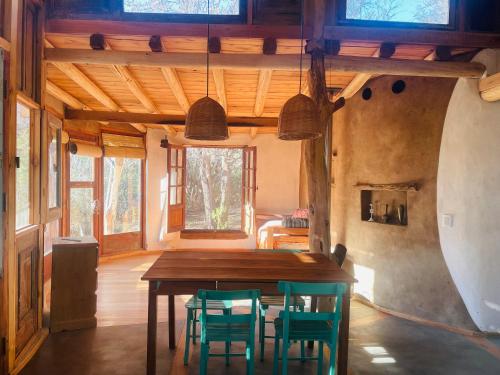 Un comedor con mesa y sillas de madera. en Casa LaMora, en San Marcos Sierras