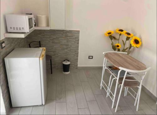 a kitchen with a refrigerator and a table and chairs at Life Vesuvio in Torre del Greco