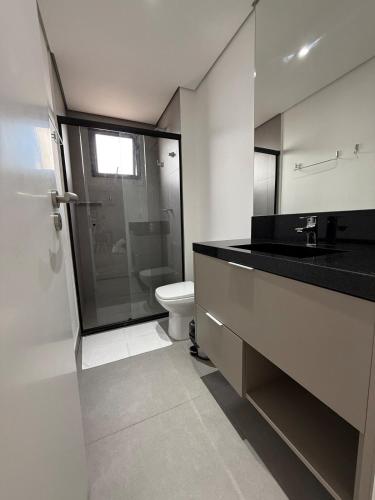 a bathroom with a toilet and a glass shower at Stay Santos - Moderno e Bem Localizado in Santos