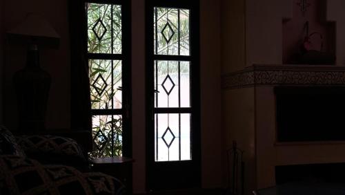 two stained glass windows in a room with a fireplace at Villa Zazate private pool & starry garden in Ouarzazate