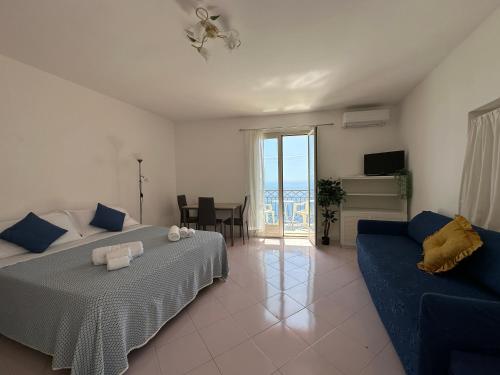 a bedroom with a bed and a blue couch at Praiano Amalfi Coast Casa con Vista Mare in Praiano