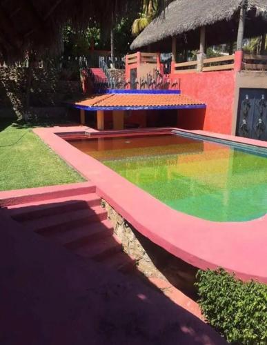 a swimming pool with pink and green paint on it at Casa Mandarina in Tequesquitengo