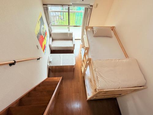 a small room with two bunk beds and a window at 西山ハウス202 in Nagasaki
