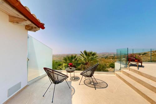 a patio with two chairs and a table on a balcony at Antico Borgo dei Templi in Agrigento