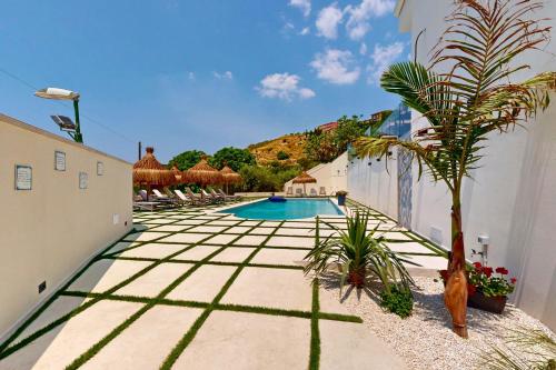 a courtyard with a pool and a palm tree at Antico Borgo dei Templi in Agrigento