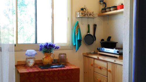 una cocina con una mesa con un jarrón de flores en Gan HaPaamonim, en Giv‘ath Binyāmīn