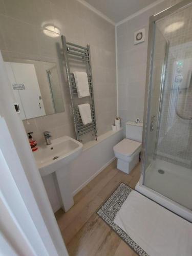 a bathroom with a sink and a shower and a toilet at OceanNest-3 Bedroom Apartment free parking, EV 22kW in Portsmouth