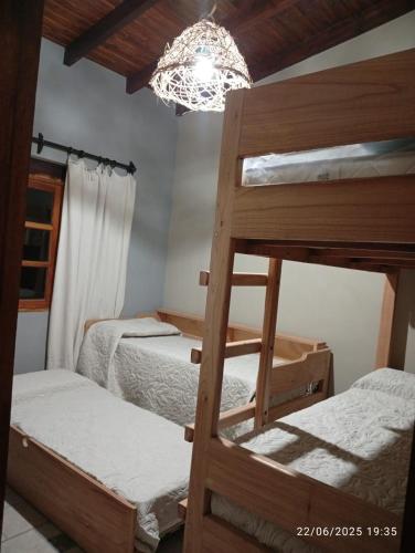 a bedroom with two bunk beds and a chandelier at Cabañas El Alemán 2 in Cerrillos
