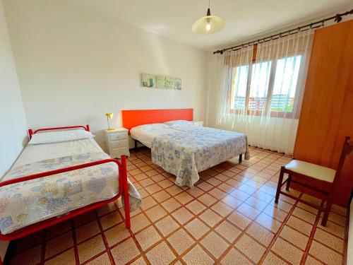 a bedroom with two beds and a table and a chair at Apartment in Porto Santa Margherita by Beach in Porto Santa Margherita di Caorle