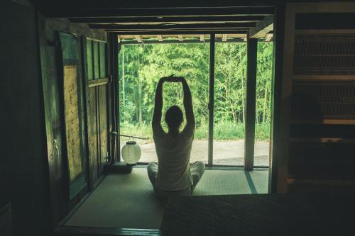 a woman doing yoga in front of a window at ame nakasendo - A 150 years old private kominka along the Nakasendo trail - in Nagiso