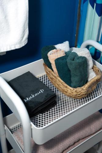 a basket of towels and a book on a shelf at Cozy 4bd House Heart of Downtown WPB Sleeps 10 in West Palm Beach