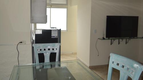 a living room with a glass table and a television at Casa Hotel Descanso Quindiano in Montenegro