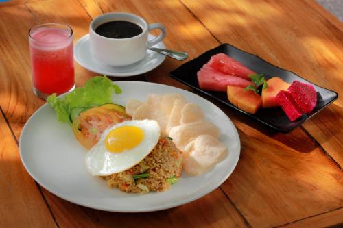 a plate of food with an egg and a cup of coffee at Sagara Villas and Suites Sanur by AHM in Sanur