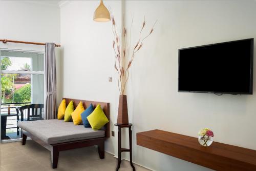 a living room with a couch with yellow pillows at Sala Siem Reap Hotel in Siem Reap
