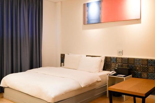 a hotel room with a bed and a table at 호텔 인썸니아 Hotel Insomnia 失眠酒店 in Daegu