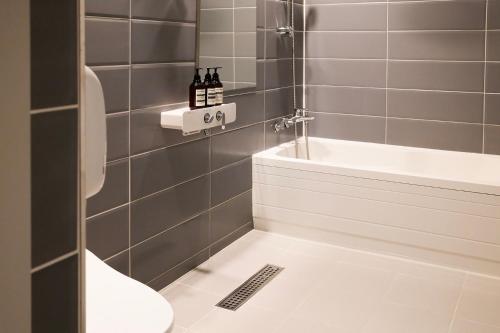 a bathroom with a shower and a toilet and a sink at 호텔 인썸니아 Hotel Insomnia 失眠酒店 in Daegu