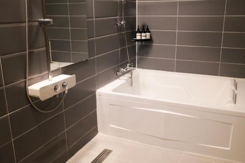 a bathroom with a bath tub and a sink at 호텔 인썸니아 Hotel Insomnia 失眠酒店 in Daegu