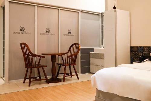 a room with two chairs and a table and a bed at 호텔 인썸니아 Hotel Insomnia 失眠酒店 in Daegu