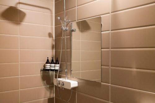 a bathroom with a shower with two bottles of wine at 호텔 인썸니아 Hotel Insomnia 失眠酒店 in Daegu