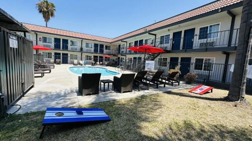 a courtyard with a pool and chairs and a building at Studio 6 Suites San Ysidro CA San Diego South Bay in San Ysidro, San Diego