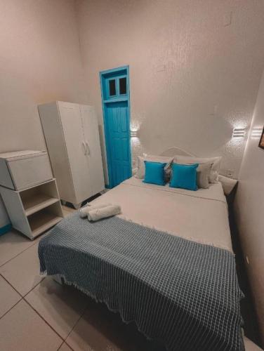 a bedroom with a large bed with blue pillows at Piratas da Vila in Jericoacoara