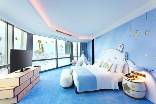 a blue bedroom with a bed and a tv at Grand Hyatt Changsha-Close to Helong Sports Center in Changsha