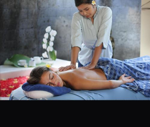 a woman getting a massage from a therapist at Sagara Villas and Suites Sanur by AHM in Sanur