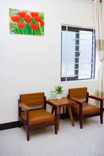 a room with two chairs and a table and a window at Gold Stone Hoi An Homestay in Hoi An