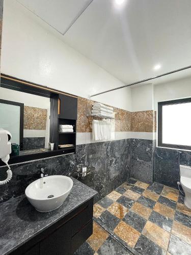 a bathroom with a sink and a toilet and a mirror at Xanh Melody Resort in Bắc Ninh