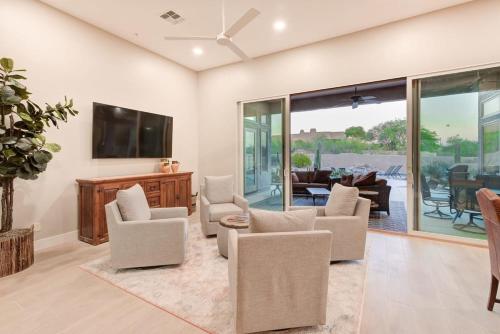 a living room with chairs and a flat screen tv at Scottsdale Luxury Heated Pool Desert Views For 6 in Scottsdale
