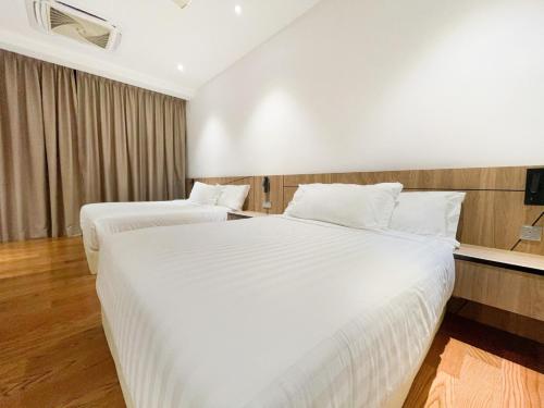 two beds in a hotel room with white sheets at La Villa Langkawi - Private Pool in Pantai Cenang