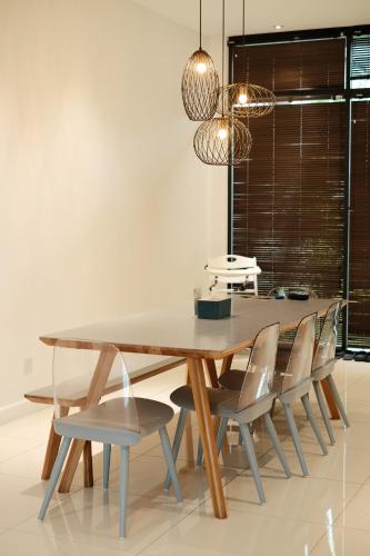 a dining room with a wooden table and chairs at La Villa Langkawi - Private Pool in Pantai Cenang