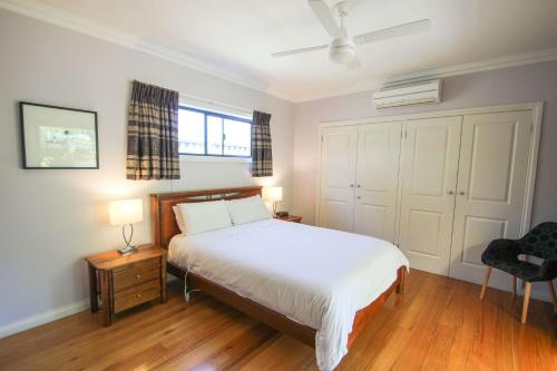 1 dormitorio con 1 cama, 2 lámparas y 1 silla en Mountbatten Retreat, en Bright