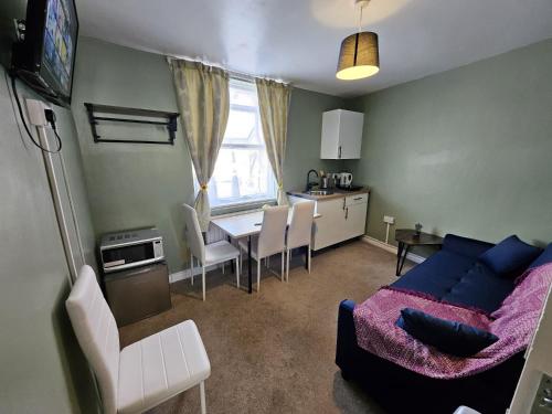 a living room with a blue couch and a table at OceanNest-3 Bedroom Apartment free parking, EV 22kW in Portsmouth