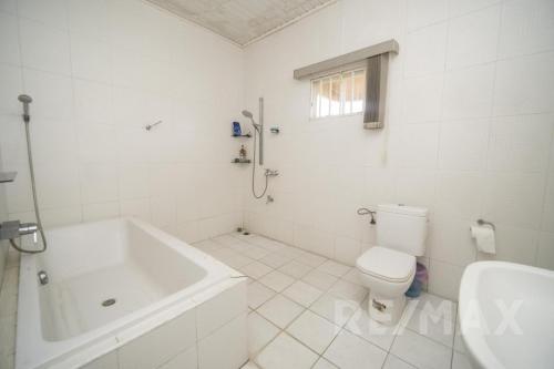 a white bathroom with a tub and a toilet at 悦心雅舍 in Paramaribo