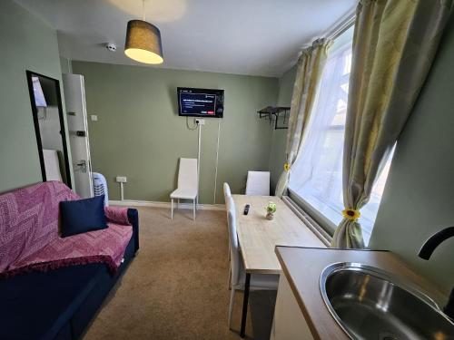 a living room with a table and a sink at OceanNest-3 Bedroom Apartment free parking, EV 22kW in Portsmouth
