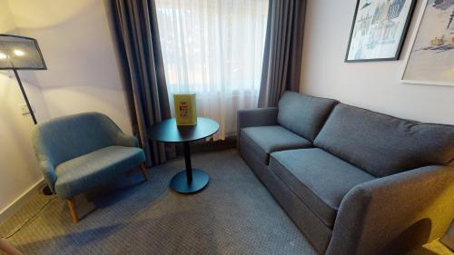 a living room with a couch and a chair at Holiday Inn Cambridge by IHG in Cambridge