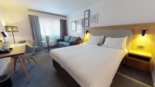 a hotel room with a large bed and a desk at Holiday Inn Cambridge by IHG in Cambridge